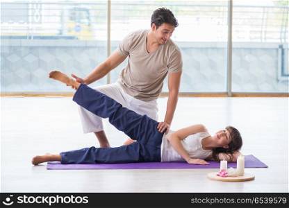 Personal trainer assisting during exercise in sports gym