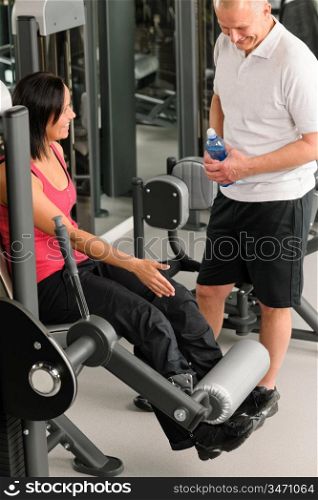 Personal trainer at fitness center showing exercise to active man