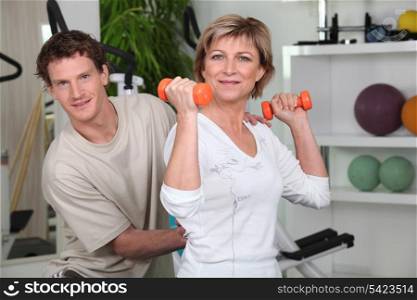 Personal trainer helping his client with her posture