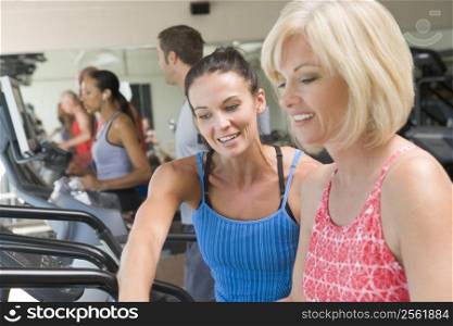 Personal Trainer Showing Woman How To Use Treadmill