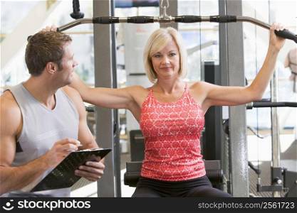 Personal Trainer Watching Woman Weight Train