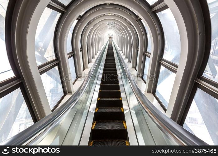 perspective escalators stairway inside contemporary blue glass business centre, concept of successful career elevation