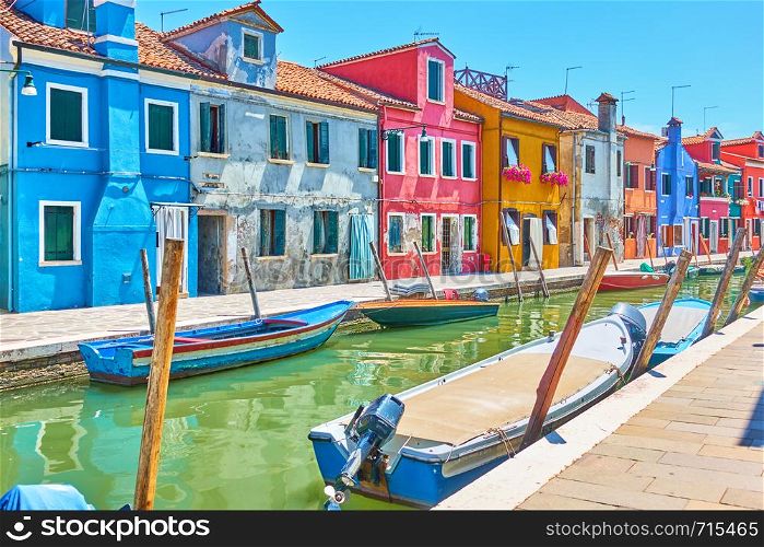 Perspective of canal with boats and picturesque houses in Burano , Venice, Italy