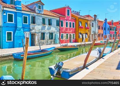 Perspective of canal with boats and picturesque houses in Burano , Venice, Italy