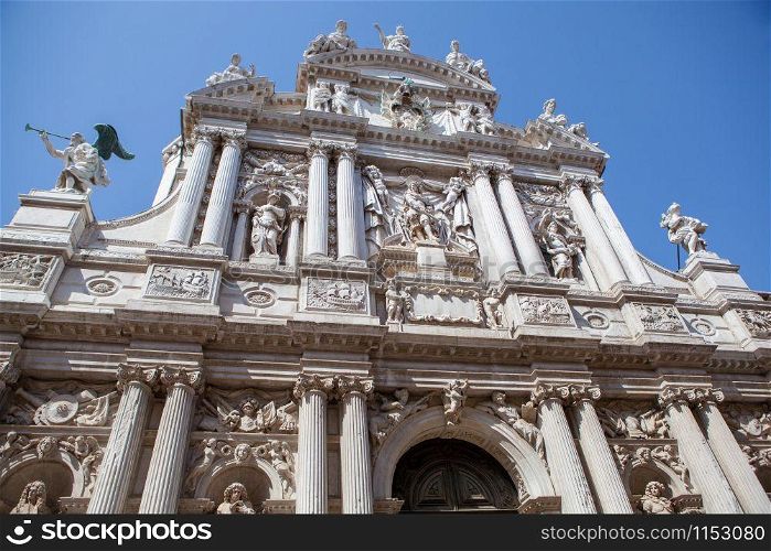 Perspective view old-fashioned facade of historical Palace cathedral in Venice, Italy on a blue sky background.. Facade of historical building of Palace in Venice.