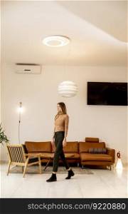 Pertty young woman walking through modern livingroom