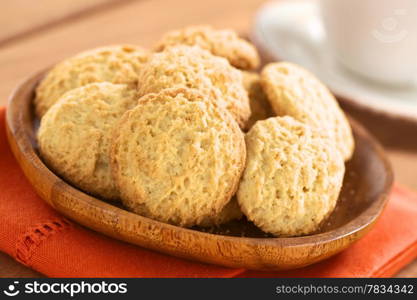 Peruvian cookies made with powdered maca or Peruvian ginseng (lat. Lepidium meyenii) with a coffe cup in the back (Selective Focus, Focus on the front of the cookies). Peruvian Cookies Made with Maca Powder