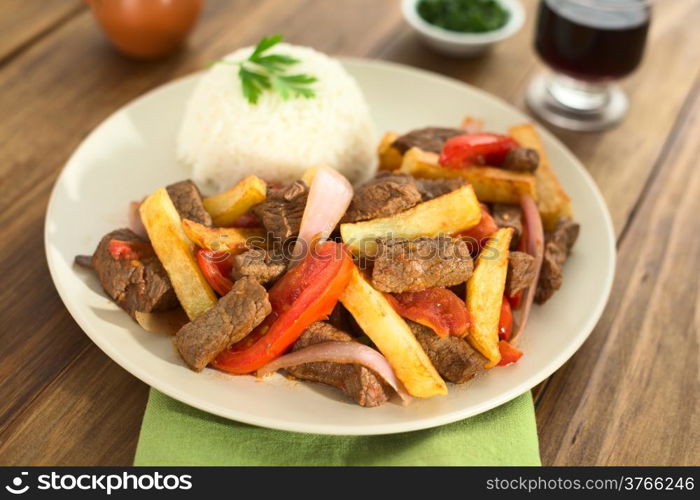 Peruvian dish called Lomo Saltado made of beef, tomato, red onion and French fries, served with rice (Selective Focus, Focus one third into the dish)