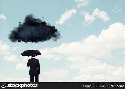 Pessimist in business. Back view of businessman with black umbrella and black cloud above