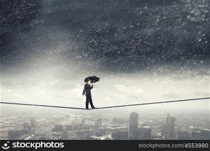 Pessimist in business. Walking on rope businessman with black umbrella