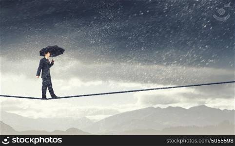 Pessimist in business. Walking on rope businessman with black umbrella