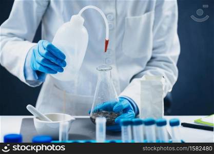 Pesticides in tea. Quality control inspector working with herbal tea sample in laboratory.. Pesticides in Tea. Quality Control Inspector Working with Herbal Tea Sample in Laboratory