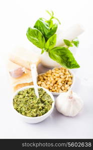 Pesto sauce ingredients: fresh green basil, parmesan, pine nuts and garlic. On white