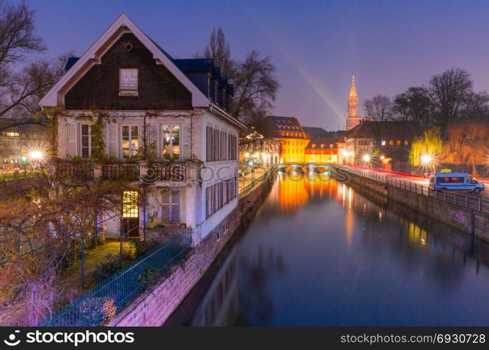 Petite France in the morning, Strasbourg, Alsace. Traditional Alsatian half-timbered houses in Petite France, bridge and river embankment Ile during morning blue hour, Strasbourg Cathedral in the background, Strasbourg, Alsace, France