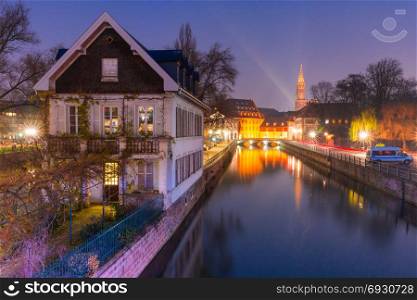 Petite France in the morning, Strasbourg, Alsace. Traditional Alsatian half-timbered houses in Petite France, bridge and river embankment Ile during morning blue hour, Strasbourg Cathedral in the background, Strasbourg, Alsace, France