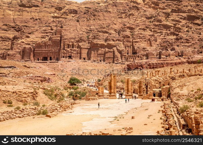 Petra main street with ancient Nabataean Royal tombs in the background and ruins of grand temple in the foreground, Petra, Jordan