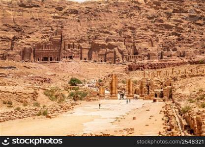 Petra main street with ancient Nabataean Royal tombs in the background and ruins of grand temple in the foreground, Petra, Jordan