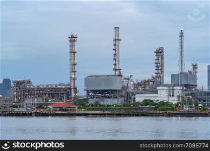 Petrochemical oil refinery and sea in industrial engineering concept in Bangna district, Bangkok, Thailand. Oil and gas tanks pipelines in industry. Modern metal factory.