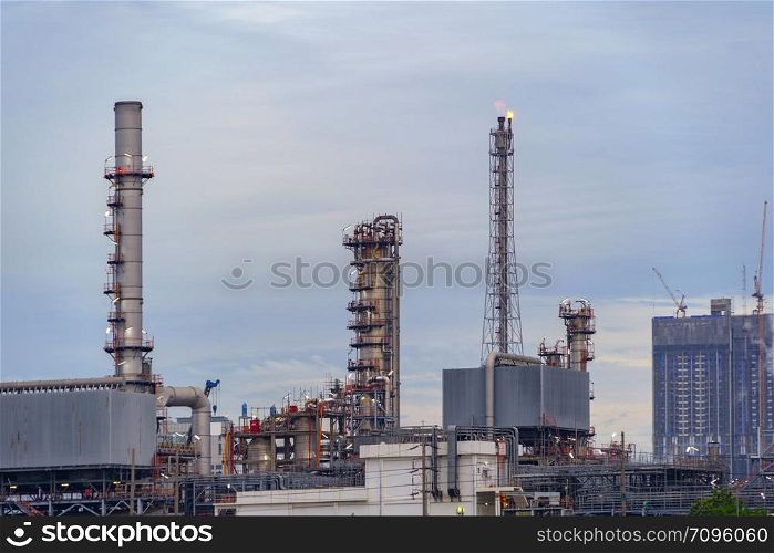 Petrochemical oil refinery and sea in industrial engineering concept in Bangna district, Bangkok, Thailand. Oil and gas tanks pipelines in industry. Modern metal factory.