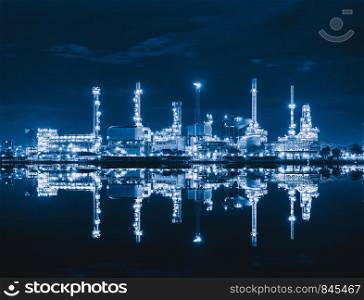 Petrochemical oil refinery and sea in industrial engineering concept in Bangna district, Bangkok, Thailand. Oil and gas tanks pipelines in industry. Modern metal factory at night.
