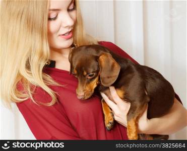 Pets and people, pet adoption. Elegant woman posing with her mixed dog pet indoor, hugging lovingly embraces her puppy.