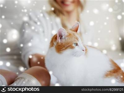 pets, animals and people concept - happy young woman with cat in bed at home over snow. happy young woman with cat in bed at home