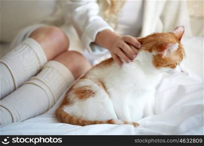 pets, animals and people concept - happy young woman with cat in bed at home