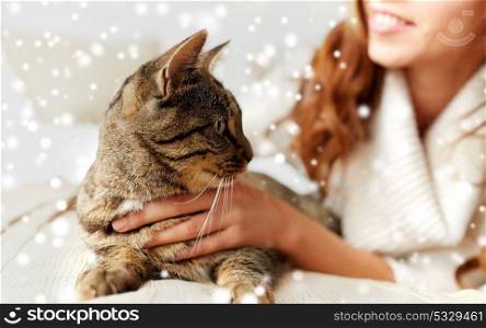 pets, animals, winter and people concept - close up of cat and woman in bed over snow. close up of cat and woman in bed