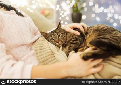 pets, hygge and people concept - close up of female owner with tabby cat in bed at home. close up of owner with tabby cat in bed at home
