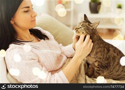 pets, hygge and people concept - close up of woman with tabby cat in bed at home. close up of woman with tabby cat in bed at home