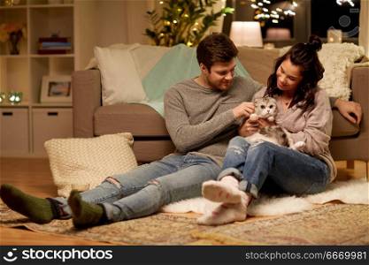 pets, hygge and people concept - happy couple with cat at home. happy couple with cat at home. happy couple with cat at home