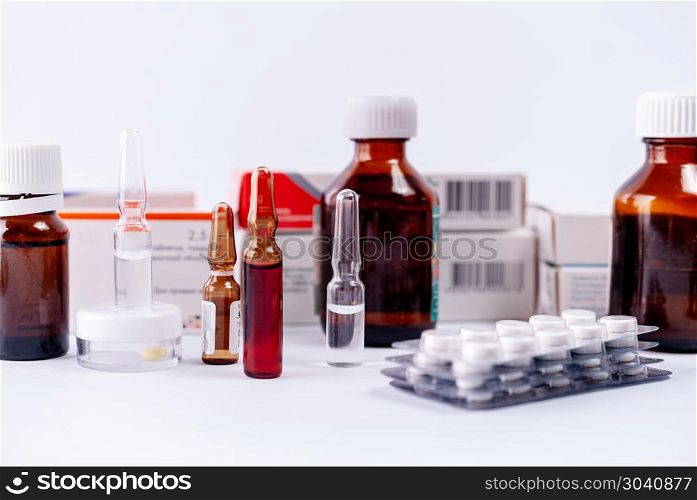 Pharmaceutical colorful pills, capsules, ampoules on white background. Ampoules, pills, packs with medicine remedy, vitamins on a white background