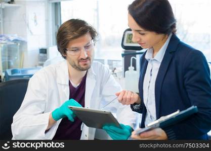 pharmaceutical scientist looking at information on the tablet