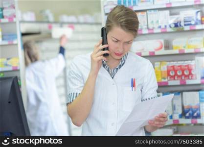 pharmacist reading the list on the telephone