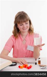 Pharmacist sitting at the table reading a thick handbook of medicines