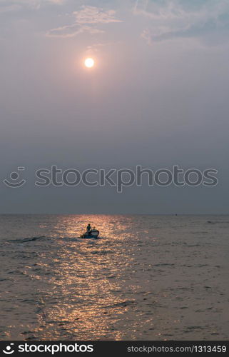 Phetchaburi,Thailand - Mar 15, 2020 : The fisherman and wooden fishing boat used as a vehicle for finding fish in the sea. Selective focus.