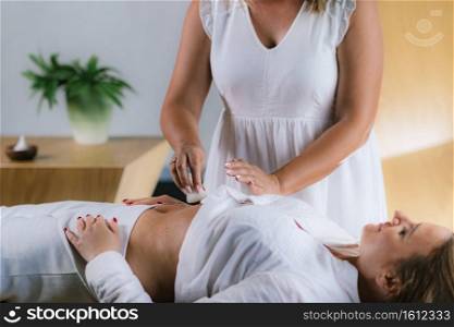 Philippine Psychic Surgery Healer Using Cotton Balls and Water for Treatment. Female Patient Laying on Back.. Spiritual Healer Using Cotton Balls and Water for Philippine Psychic Surgery Treatment