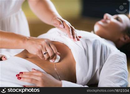 Philippine Psychic Surgery Healer Using Cotton Balls and Water for Treatment. Female Patient Laying on Back.. Spiritual Healer Using Cotton Balls and Water for Philippine Psychic Surgery Treatment