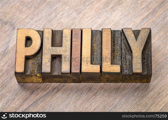 Philly (Philadelphia) word abstract in vintage letterpress wood type against grained wooden background