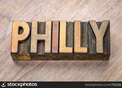 Philly (Philadelphia) word abstract in vintage letterpress wood type against grained wooden background