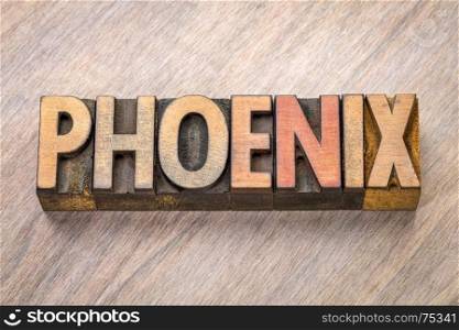 Phoenix word abstract in vintage letterpress wood type against grained wooden background