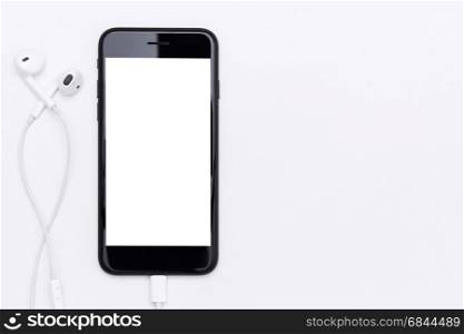phone blank screen and headphone on white table top view