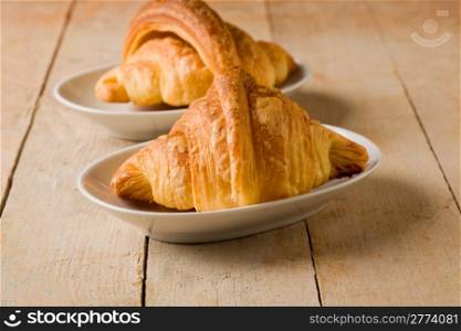 phot of delicious tasty golden croissants on wooden table