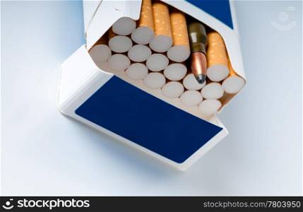 Photo concept. Open pack of cigarettes with a filter and a machine-gun cartridge
