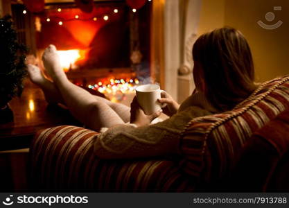 Photo from back of woman warming up fireplace at Christmas eve