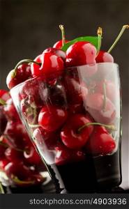 photo glass with cocktail cherries with green leaves