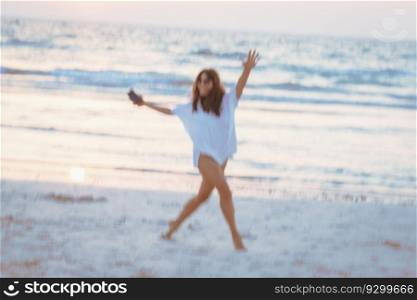 Photo in motion of a happy cheerful girl dancing on the beach. Having fun outdoors. Spending active summer weekend near the sea. Blur in motion.. Conceptual photo of a happy summer vacation