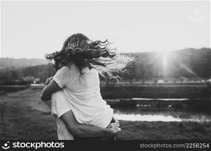 Photo married couple hugging, husband and wife near lake. Close Up. Summer. Portrait of a romantic young man and woman in love in nature. husband and wife on sunlight. Black and white photo.