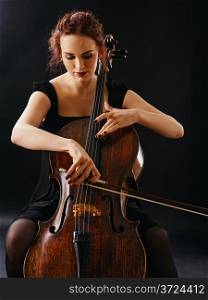 Photo of a beautiful female musician playing a cello.&#xA;
