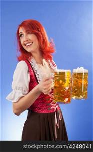 Photo of a beautiful female waitress wearing traditional dirndl and holding two mass beer steins.